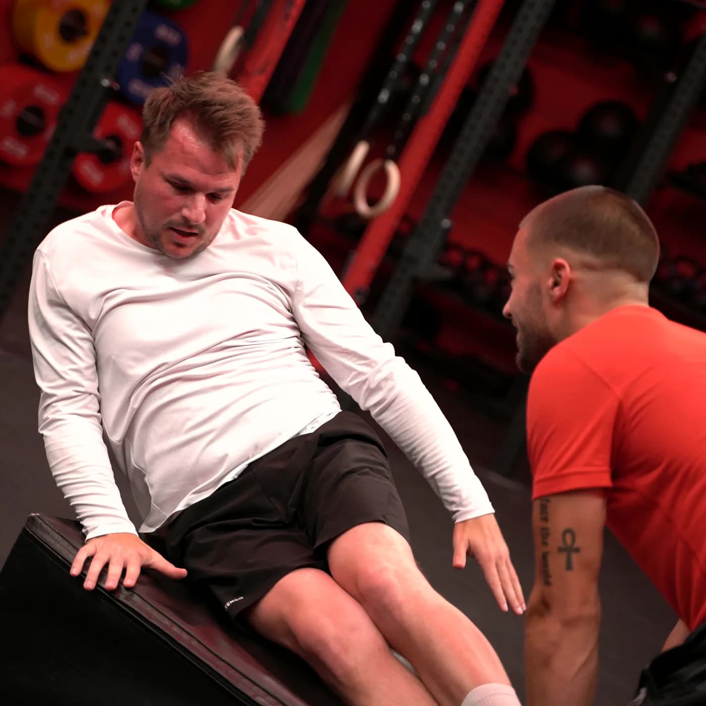 Intervalltraining im Iron Gym Viersen: Ein Teilnehmer arbeitet sichtbar angestrengt an der Plyo-Box, der Trainer treibt direkt daneben an