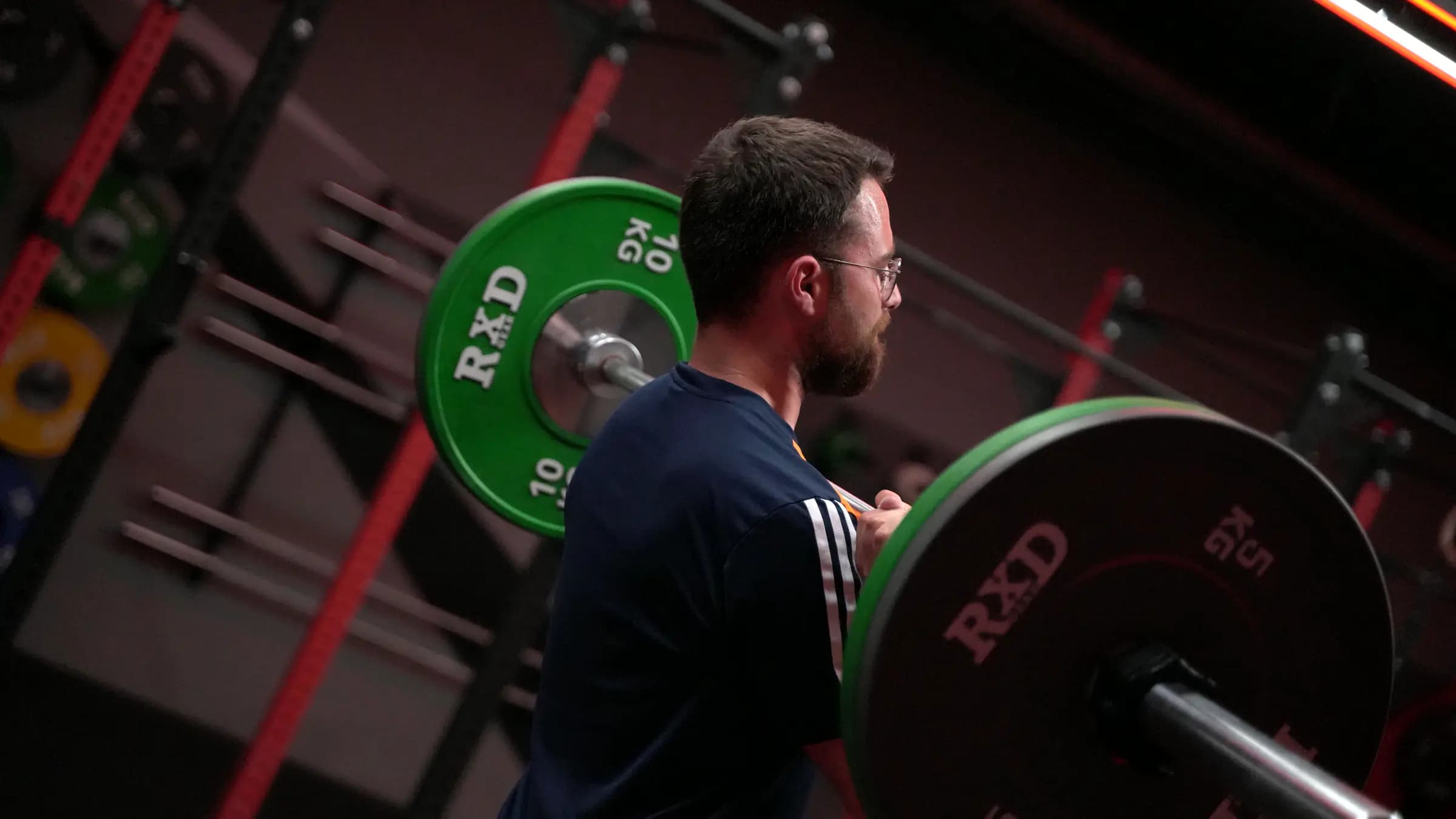 Sportler hält die Langhantel in der Frontrack-Position beim Gewichtheben im Iron Gym Viersen
