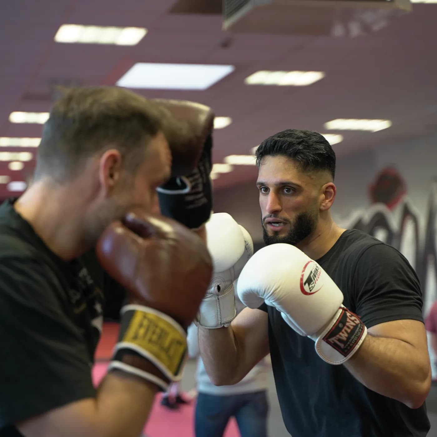 Boxtraining im Iron Gym Viersen: Ein Sportler in Deckung schlägt in die Pratzen seines Trainingspartners