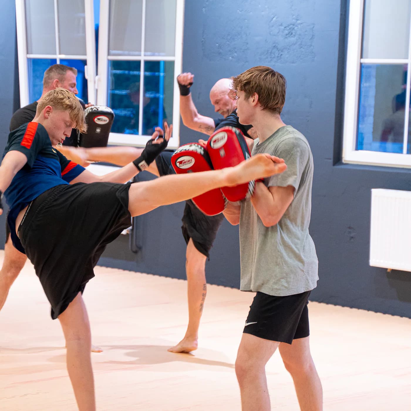 Jugendlicher tritt einen hohen Kick auf die Thai-Pratzen seines Trainingspartners im Iron Gym Viersen