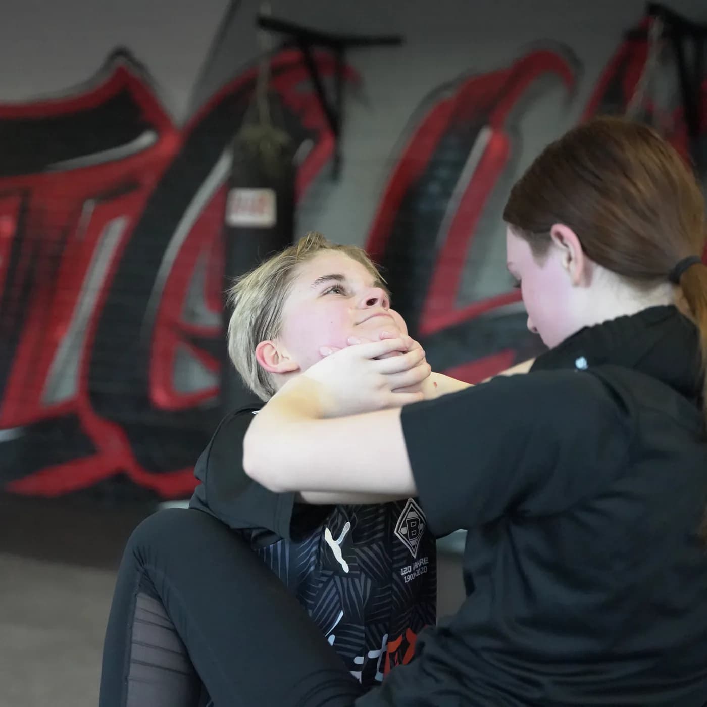 Zwei Jugendliche üben im Iron Gym Viersen einen Kontrollgriff am Kinn aus dem Clinch