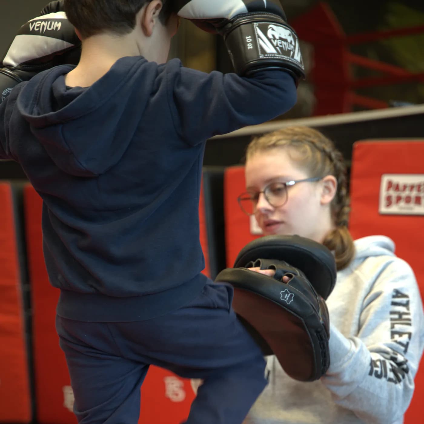 Kind tritt beim Kinder-Kickboxen gegen die Pratze der Co-Trainerin im Iron Gym Viersen