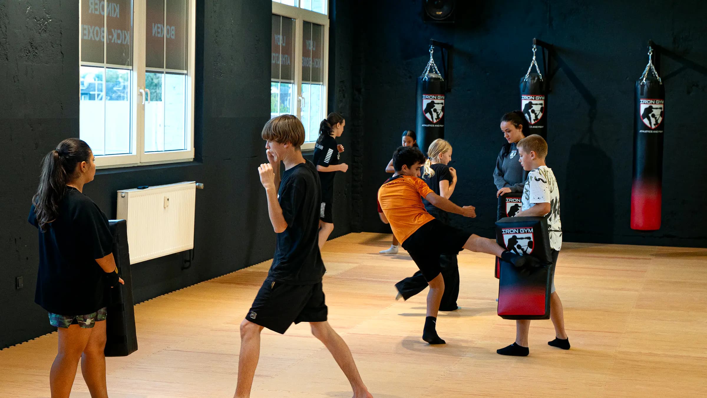Junge tritt beim Kinder-Kickboxen einen hohen Kick gegen ein Schlagpolster im Iron Gym Viersen und Dülken