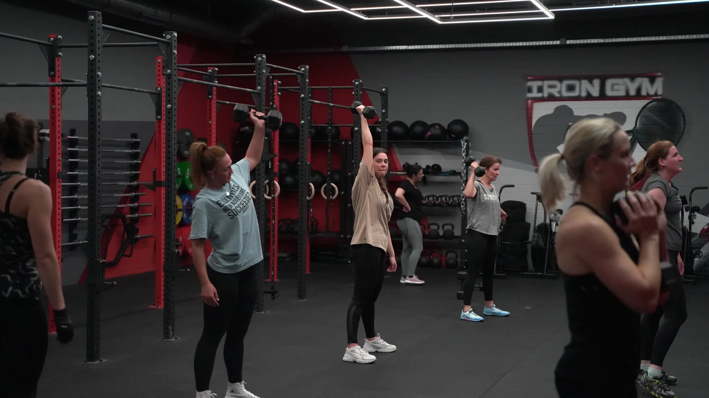 Lady Athletics im Iron Gym Viersen: Frauengruppe drückt Kurzhanteln über Kopf
