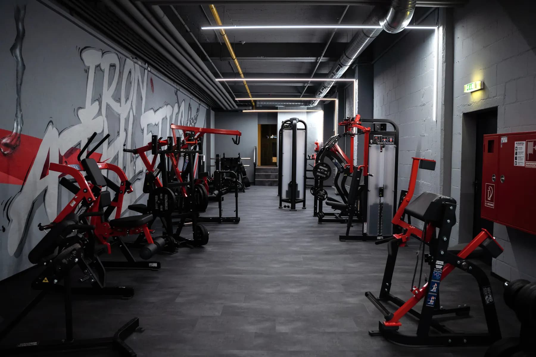 Gerätebereich im Iron Gym Viersen mit Kraftmaschinen entlang der Graffitiwand