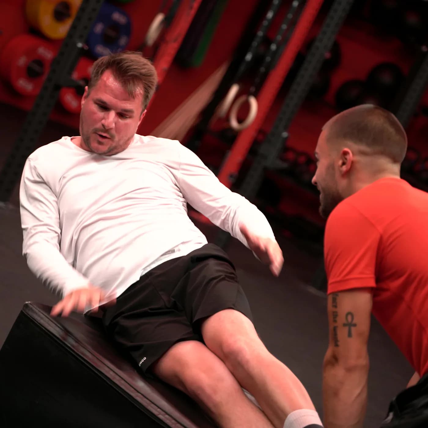 Teilnehmer arbeitet sich beim HIIT Training in Viersen über die Plyo-Box, der Trainer coacht direkt daneben